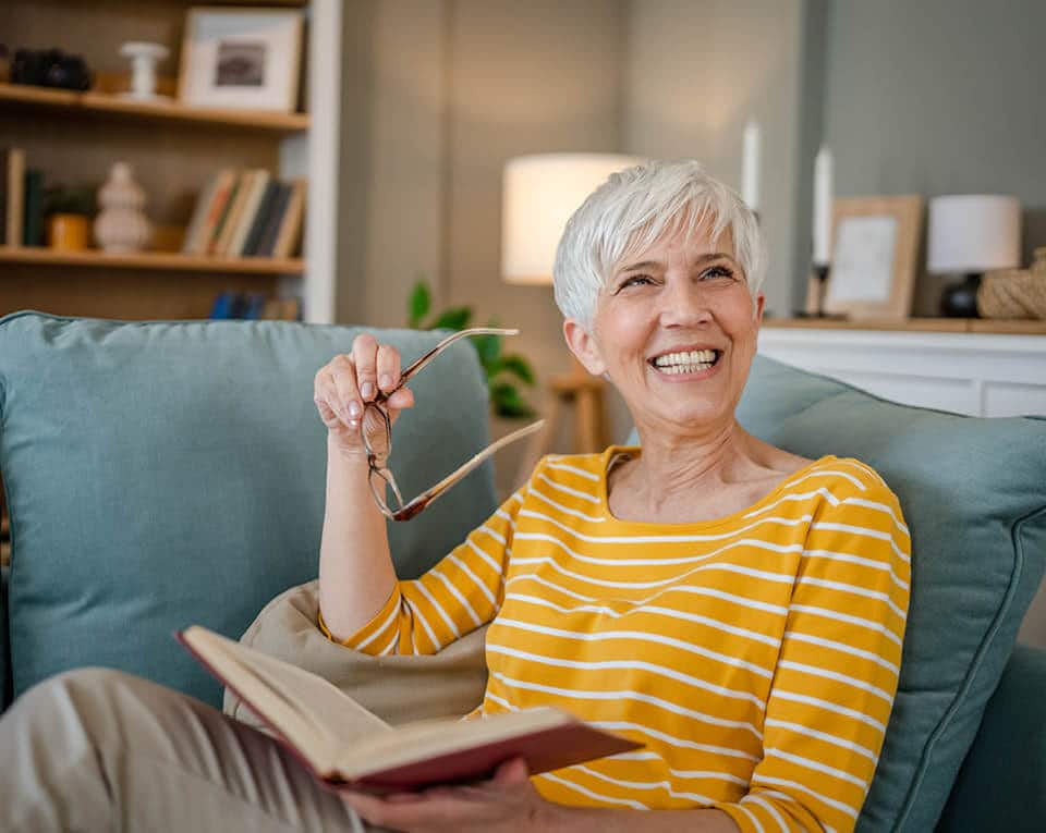 female resident smiling and holding a book