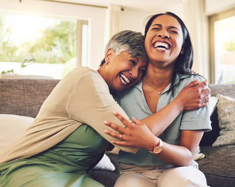 mother and daughter holding each other and laughing