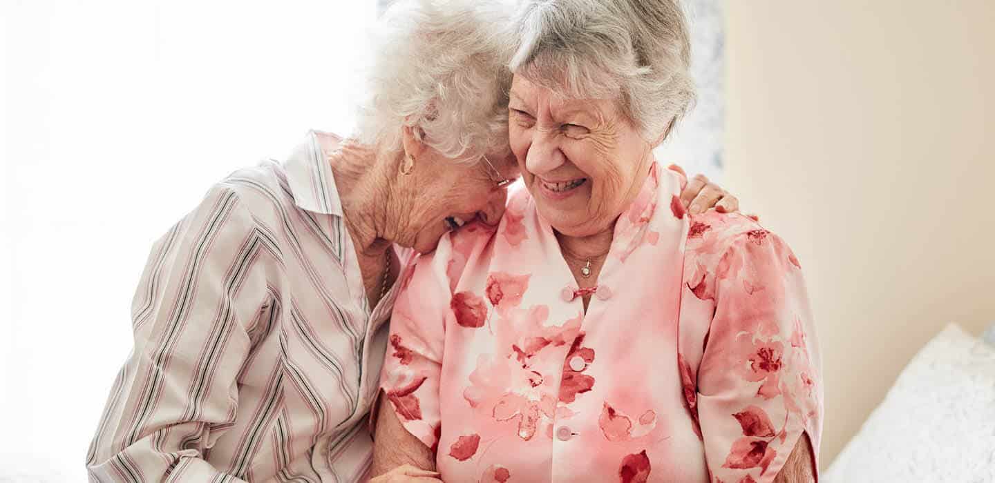 two residents holding each other and sharing a laugh